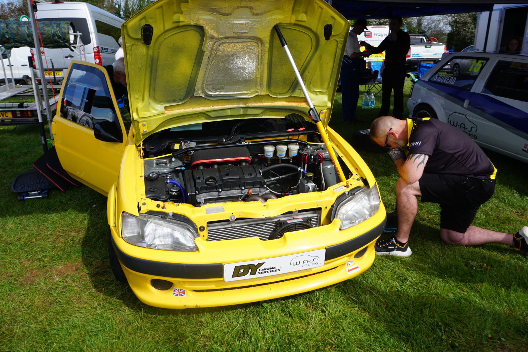 A member of ES Racing Solutions team checking over their yellow racing car