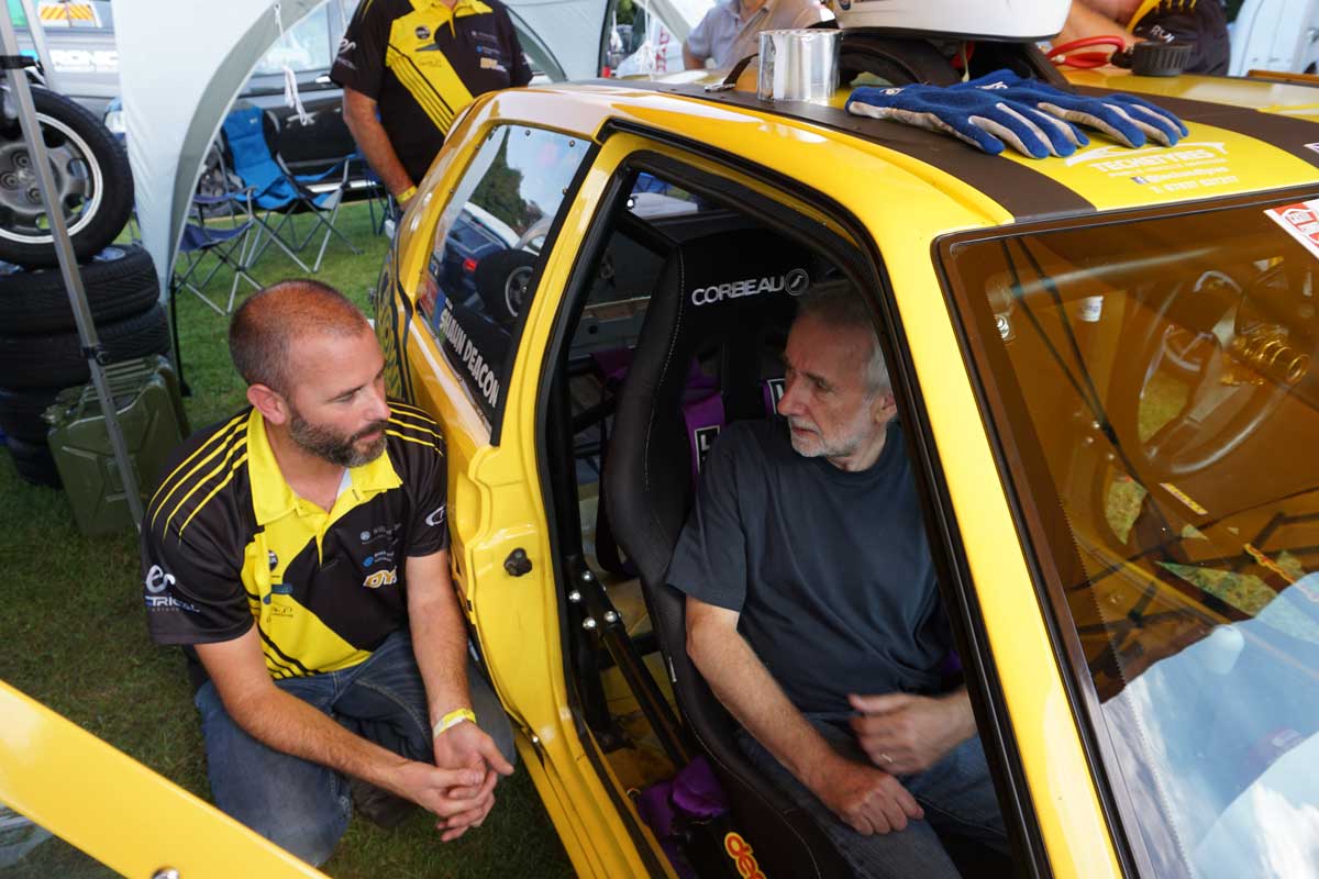 Shaun Deacon from ES Racing Solutions showing a sponsor the inside of his yellow racing car