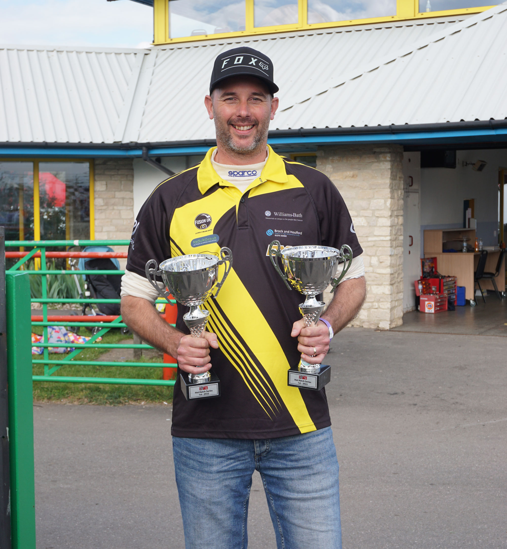 Shaun Deacon from ES racing holding two trophies the team won that day